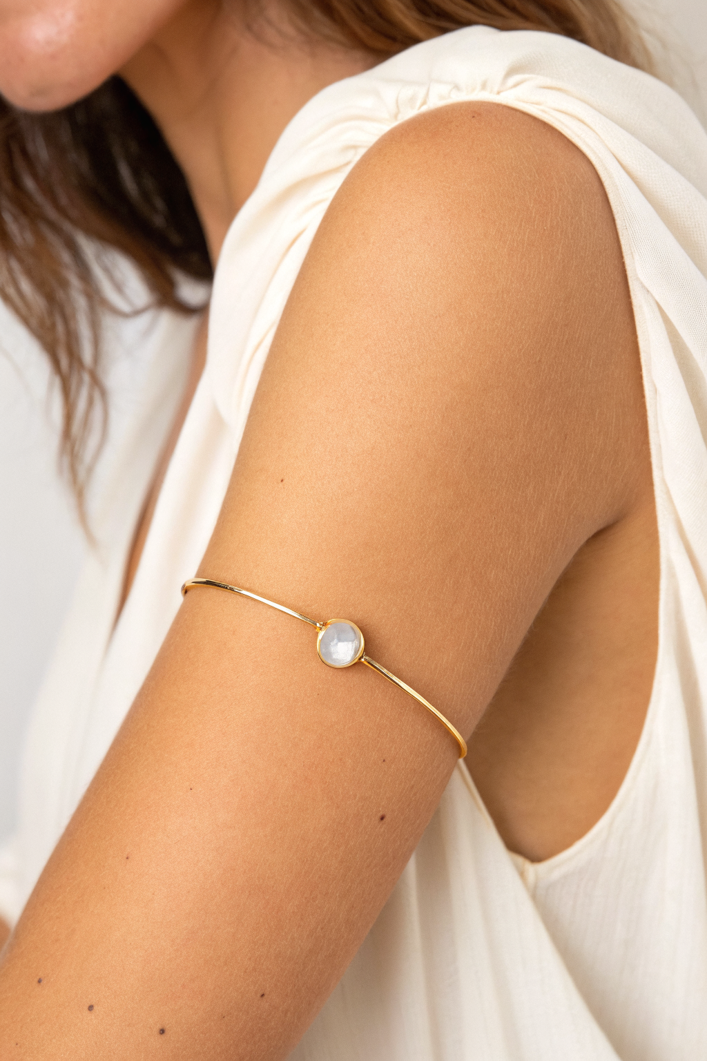 Upper arm cuff: slim gold armlet with a quartz stone