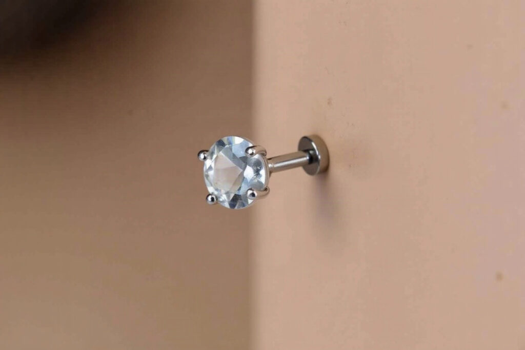 Nose piercing with a tiny quartz stone at the tip
